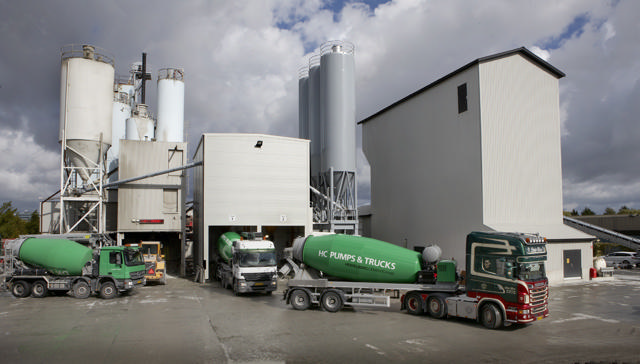 Betonwerk mit 3 Lastkraftwagen, die angekommen sind, um Beton abzuholen.