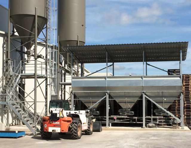 Ein Bagger parkt vor einem Materialsilo.